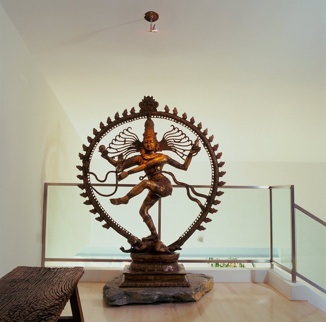 Glass and stainless steel three-level staircase of Mulholland Drive modern home featuring open design and Thai sculpture, full-service interior design by Stephen Pappas Interiors, Los Angeles