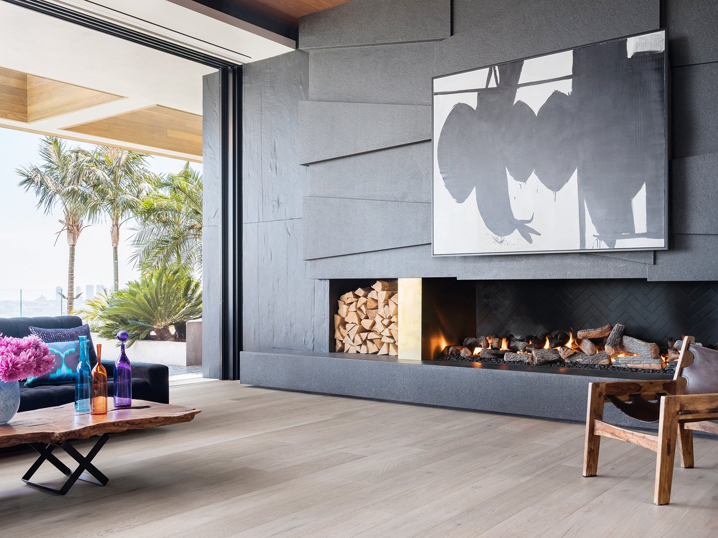 Interior styling of a luxury living room for California Classic Floors featuring modern upholstered seating and modern accents, large abstract painting, thin profiled in-wall fireplace and richly painted walls styled by Stephen Pappas Interiors, phot