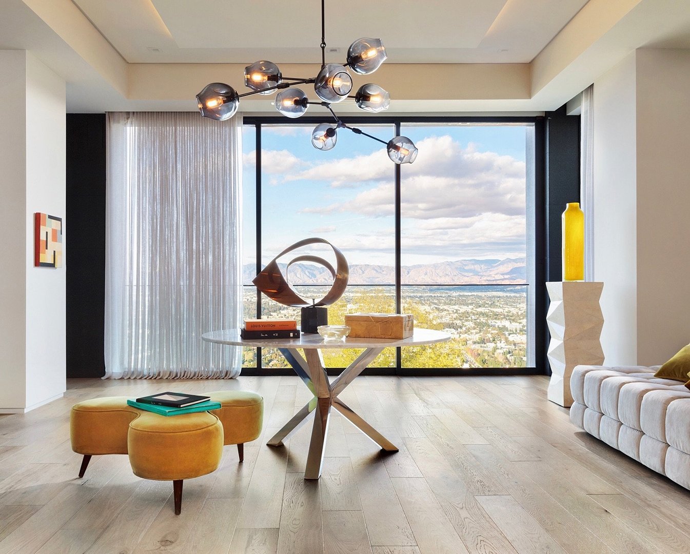 Interior styling of a modern dining nook for California Classic Floors featuring custom upholstered seating, glass table, and artful accents, styled by Stephen Pappas Interiors, photographed by Roger Davies