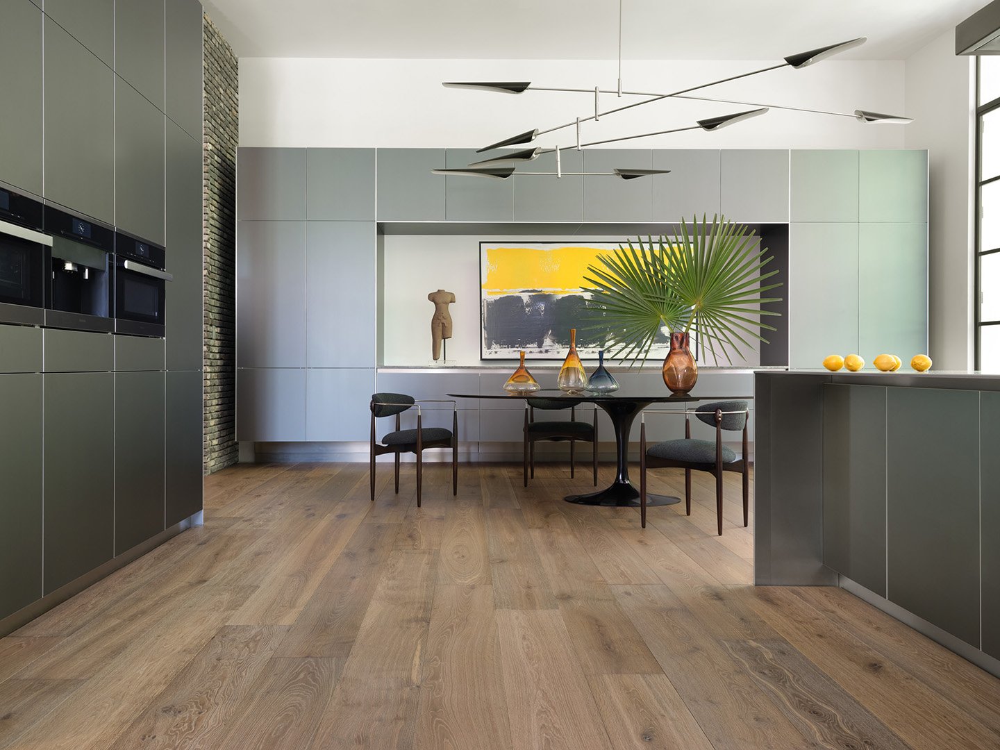 Interior styling of an open concept kitchen and dining area for California Classic Floors featuring custom modern dining table and wood chairs, a minimal kitchen island and in-wall ovens, styled by Stephen Pappas Interiors, photographed by Roger Davi