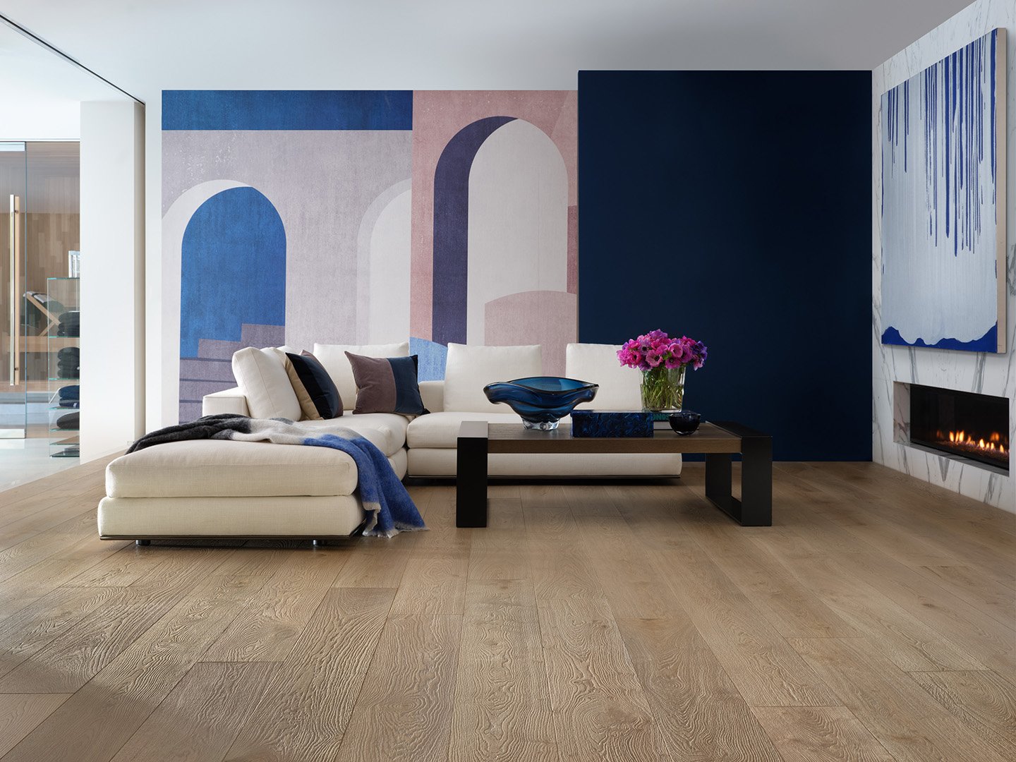 Interior styling of a luxury living room for California Classic Floors featuring modern upholstered seating and accents, large paintings and thin in-wall fireplace, and uniquely painted walls styled by Stephen Pappas Interiors, photographed by Roger