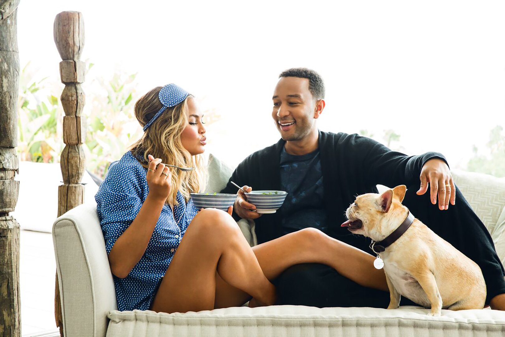 Chrissy Teigen and John Legend having breakfast on their couch in their luxury Los Angeles home styled by Stephen Pappas Interiors for Cravings cookbook, photographed by Aubrie Pick